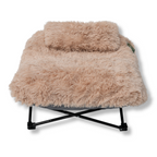 NapZZZ Fuzzle Ligstoel met kussen - Beige, vooraanzicht van de verhoogde stoel met kussen eraan vast. De stoel zit vaste een een zwart metalen onderstel.