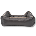 Napzzz divan waterproof antraciet in achter aanzicht. Stevige hondenmand van oxford materiaal dat waterafstotend is. De randen zijn zeer stevig gevuld met schuimvlokken voor extra steun en comfort. Uitneembare liggedeelte met schuimrubber matras. De mand is geheel voorzien van ritssluiting aan de binnenkant. Mooi afgewerkt en voorzien van napzzz logo. Verkrijgbaar in meerdere maten.