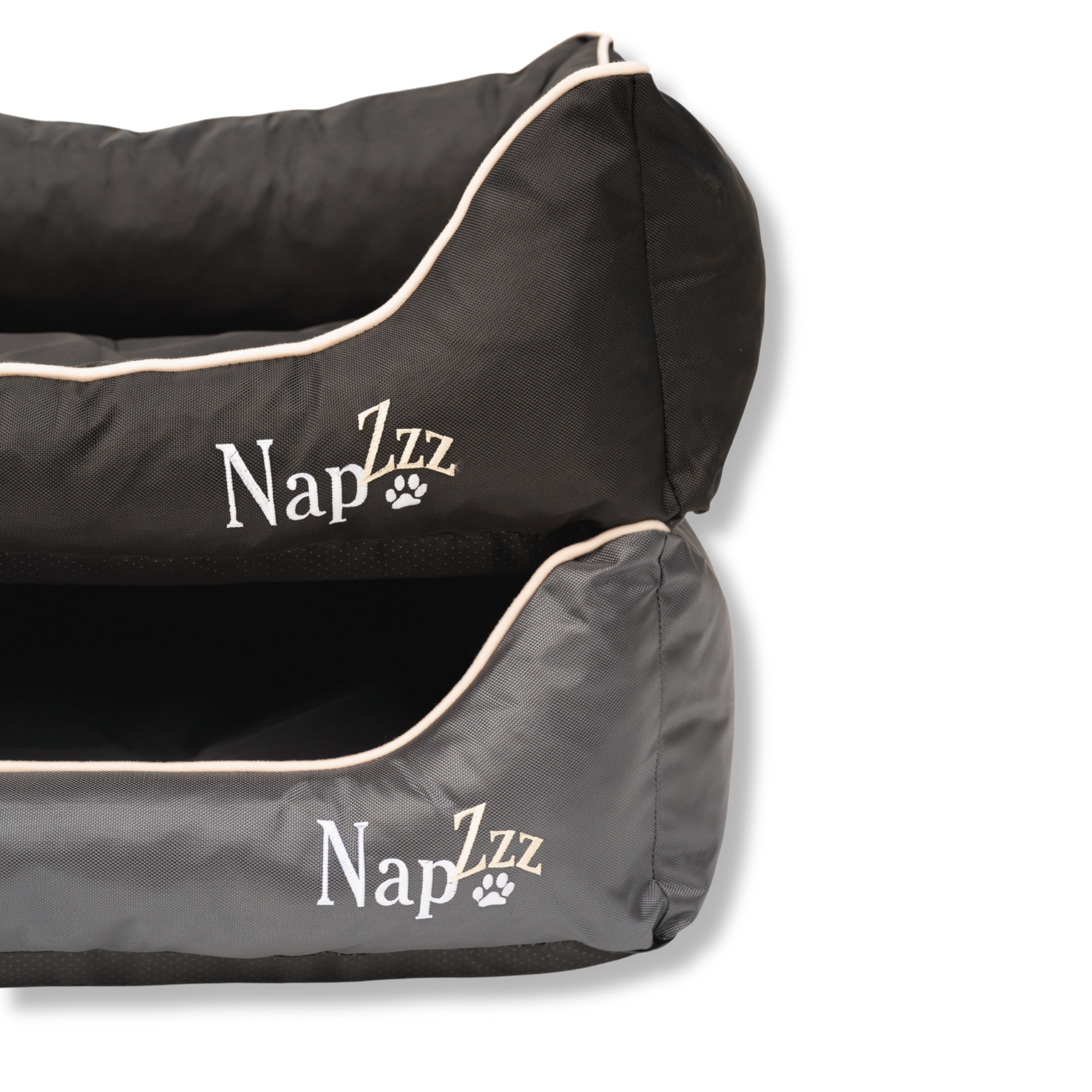 Napzzz divans waterproof antraciet en zwart in vooraanzicht. Stevige hondenmand van oxford materiaal dat waterafstotend is. De randen zijn zeer stevig gevuld met schuimvlokken voor extra steun en comfort. Uitneembare liggedeelte met schuimrubber matras. De mand is geheel voorzien van ritssluiting aan de binnenkant. Mooi afgewerkt en voorzien van napzzz logo. Verkrijgbaar in meerdere maten.