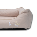 Close-up van de NapZZZ divan in beige, gemaakt van stevig oxford materiaal – duurzame hondenmand met wasbare bekleding en strakke afwerking.