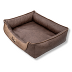 Napzzz Divan hondenmand leatherlook duo in zijaanzicht op witte achtergrond. Stevige gevulde randen met schuimrubberen vlok en uitneembaar ligmatras. Luxe afgewerkt met biesrand en napzzz logo. In diverse maten verkrijgbaar