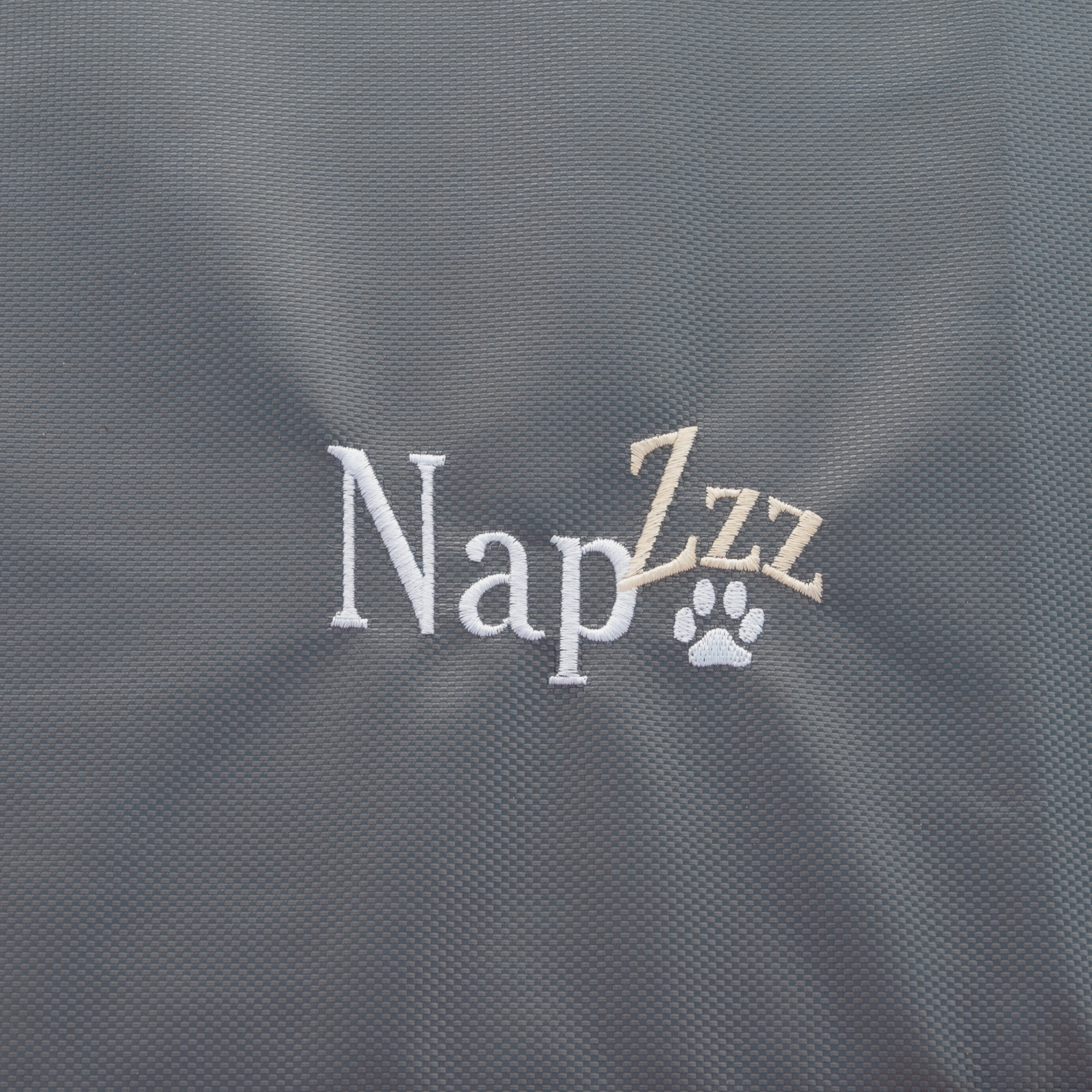 Napzzz benchmatras oxford antraciet in detail van stof en geborduurde napzzz logo.