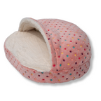 Napzzz cuddle cave dotz voor kat of kleinere hond in roze kleur in zijaanzicht. Schuimrubber matras met zacht pluche hoes voorzien van gekleurde stippen. Opstaande bovenkant dat werkt als deken en zorgt voor knusse ligplek. 