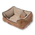 NapZZZ divan beige met kussen voor honden in zijaanzicht. De mand is zeer stevig gevuld in de opstaande randen voor extra steun en comfort. 
De buitenstof heeft een fluweel look en de binnenzijde is bekleed met blokjes relief. Tevens voorzien van en afneembaar kussentje. Het liggedeelte is voorzien van een uitneembaar en omkeerbaar ligmatras. De ene kant is voorzien van blokjes relief en de andere zijde is voorzien van effen bruine stof zoals de buitenzijde. Mand voorzien van ritssluiting aan binnenzijde.