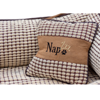 NapZZZ divan beige met kussen voor honden in detail. De mand is zeer stevig gevuld in de opstaande randen voor extra steun en comfort. 
De buitenstof heeft een fluweel look en de binnenzijde is bekleed met blokjes relief. Tevens voorzien van en afneembaar kussentje. Het liggedeelte is voorzien van een uitneembaar en omkeerbaar ligmatras. De ene kant is voorzien van blokjes relief en de andere zijde is voorzien van effen bruine stof zoals de buitenzijde. Mand voorzien van ritssluiting aan binnenzijde.