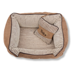 NapZZZ divan beige met kussen voor honden van bovenaf gezien. Mand is zeer stevig gevuld in de opstaande randen voor extra steun en comfort. 
De buitenstof heeft een fluweel look en de binnenzijde is bekleed met blokjes relief. Tevens voorzien van en afneembaar kussentje. Het liggedeelte is voorzien van een uitneembaar en omkeerbaar ligmatras. De ene kant is voorzien van blokjes relief en de andere zijde is voorzien van effen bruine stof zoals de buitenzijde. Mand voorzien van ritssluiting aan binnenzijde.